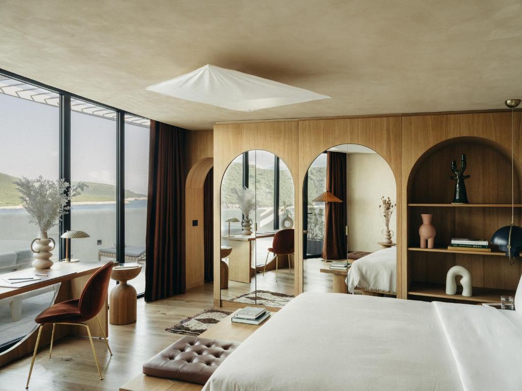 een slaapkamer met een groot bed, een bureau en stoelen bij Mamula Island in Herceg-Novi