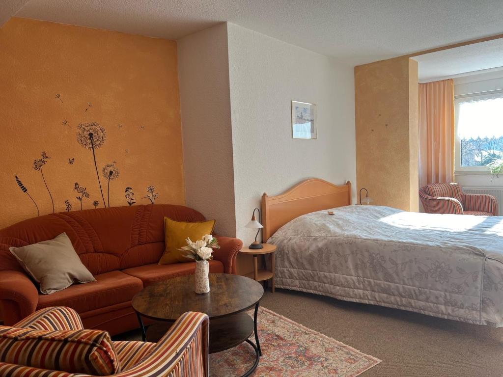 una camera d'albergo con letto, divano e tavolo di Landhaus Pusteblume a Quedlinburg