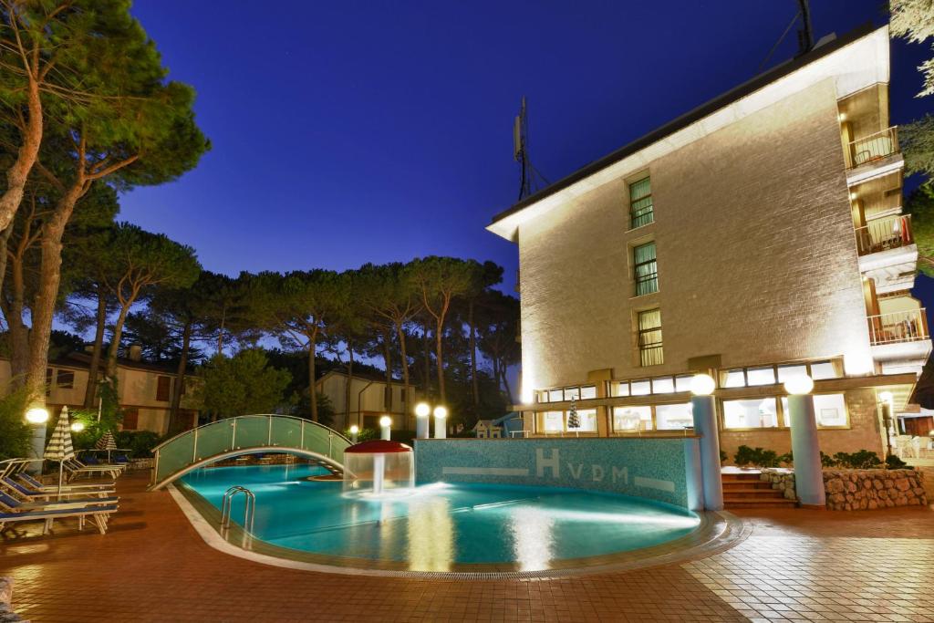 una piscina frente a un hotel por la noche en Hotel Vina De Mar, en Lignano Sabbiadoro