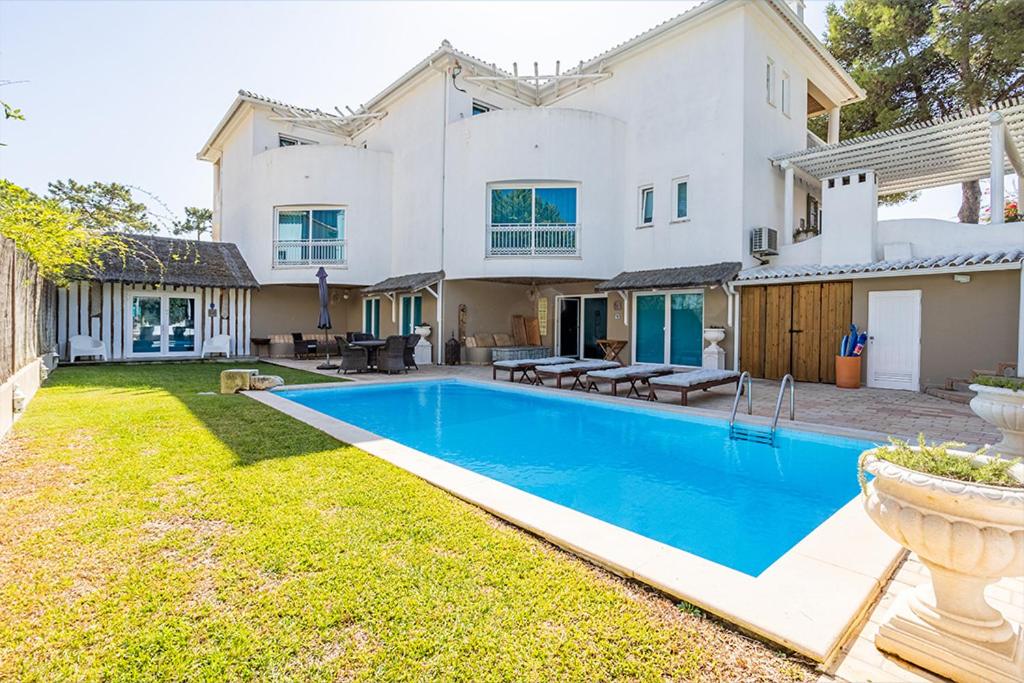 una gran casa blanca con una piscina en el patio en Kochab Comporta, en Comporta