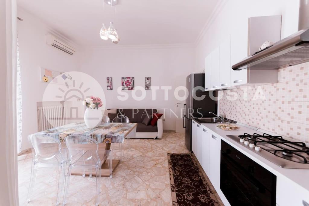 cocina blanca con mesa y fogones en Floral Flat - Porto Cesareo, en Porto Cesareo