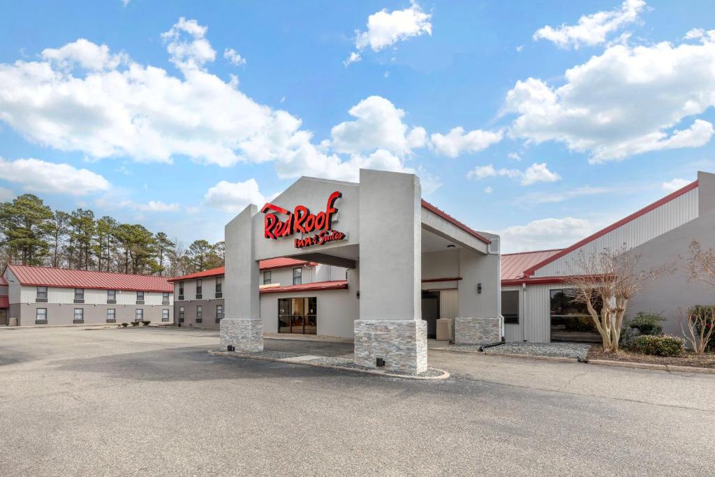 un immeuble avec un panneau coca cola dans un parking dans l'établissement Red Roof Inn & Suites Newport News, à Newport News