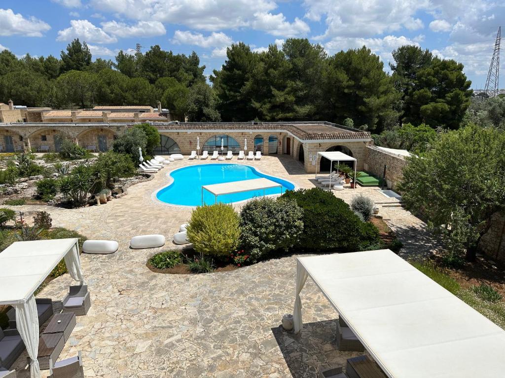 un complejo con piscina en un patio en Masseria Relais Santa Teresa, en Sannicola