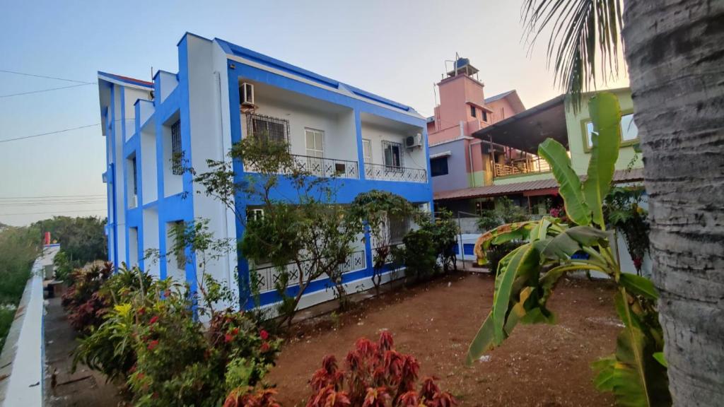 un edificio blu e bianco con piante davanti di Muktai Nest ad Alibaug