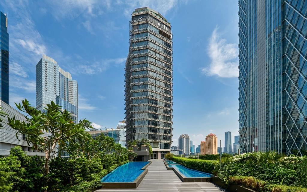 ein hohes Gebäude mit Pool in einer Stadt in der Unterkunft Alila SCBD Jakarta in Jakarta