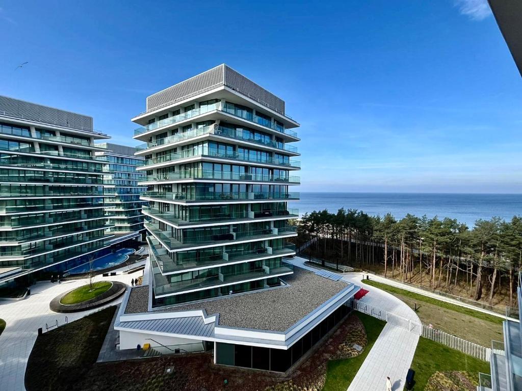 米兹多洛杰Blue Reef 6th Floor Sea View的一座高大的建筑,背靠大海