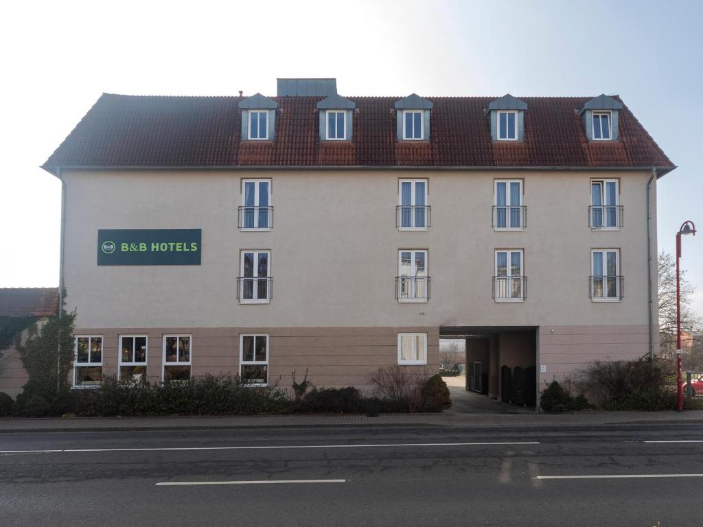 een groot wit gebouw met een bord erop bij B&B HOTEL Gotha-Hbf in Gotha