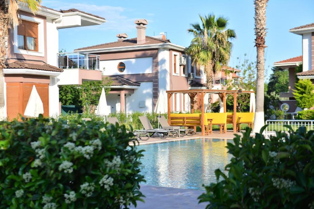 una casa con piscina frente a una casa en Pak Family Villas, en Antalya