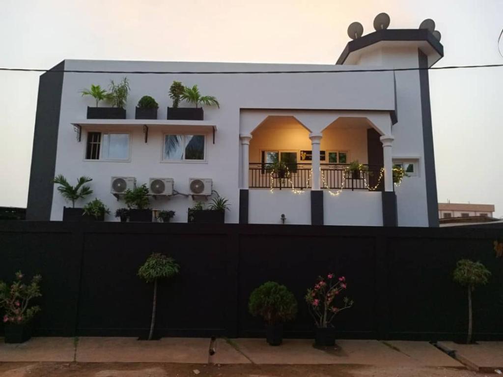 RESIDENCE MGA HOTEL في Ouidah: منزل أمامه سور أسود