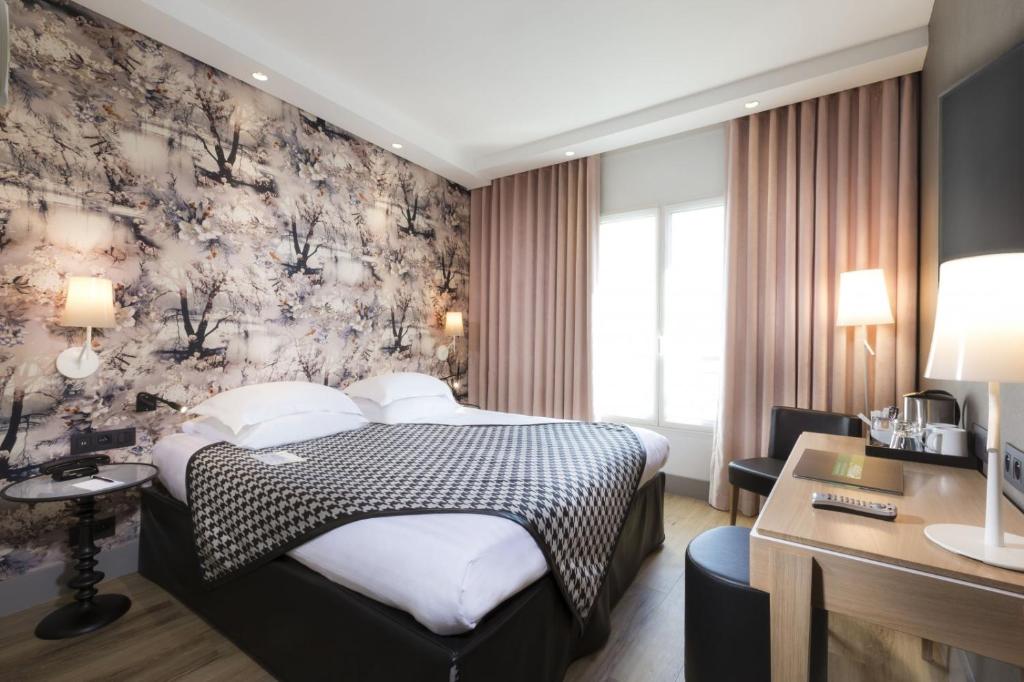 Habitación de hotel con cama y escritorio en Hotel Acanthe - Boulogne Billancourt, en Boulogne-Billancourt