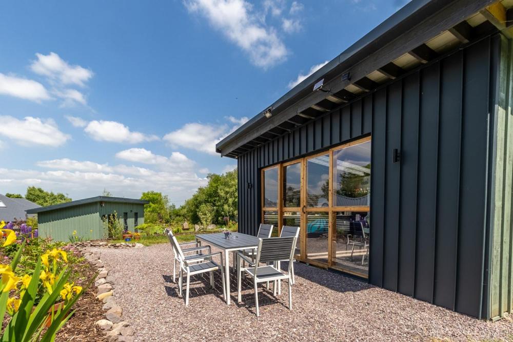 un patio avec une table et des chaises à côté d'un bâtiment dans l'établissement Mount Hillary Holiday Pods, à Cork