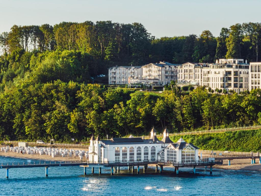 un grand bâtiment sur l'eau à côté d'une jetée dans l'établissement Hotel Bernstein, à Sellin