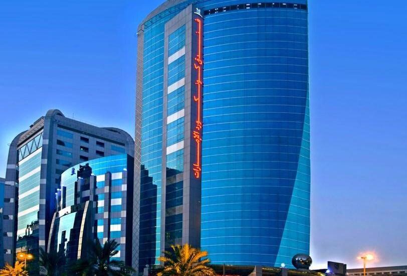 un alto edificio blu con palme di fronte di ROYAL CONCORDE HOTEL&SUITE a Dubai