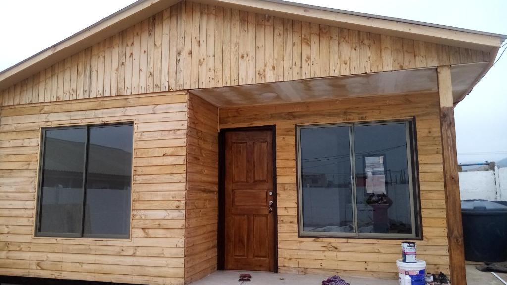 uma casa de madeira com duas janelas e uma porta em Cabañas La Herradura em Coquimbo