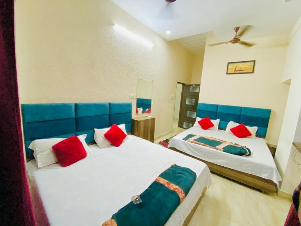 1 dormitorio con 2 camas y almohadas azules y rojas en Arora classic guest house, en Amritsar