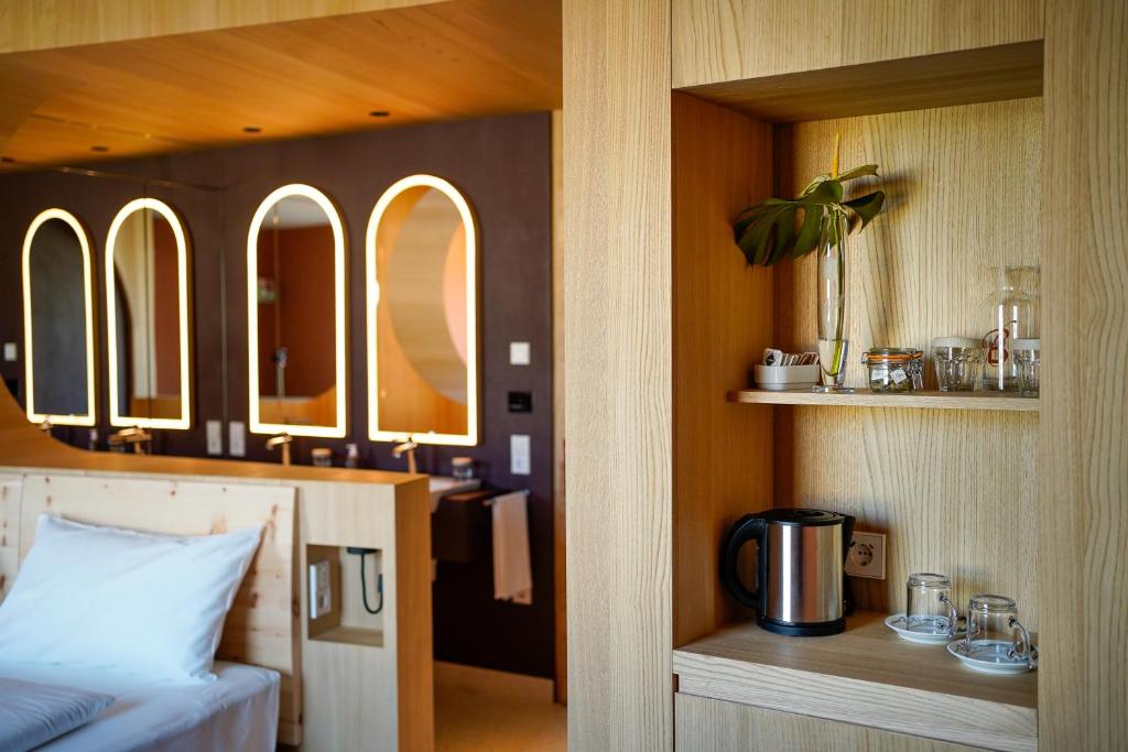 a bedroom with a bed and a sink with mirrors at Hotel La Briosa in Bolzano