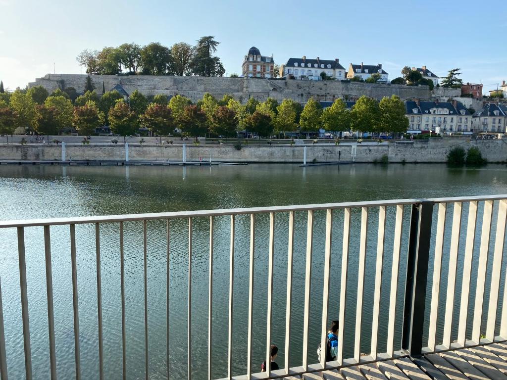 twee mensen op een brug over een rivier bij Résidence Amaya - haut standing au bord de l'Oise in Pontoise