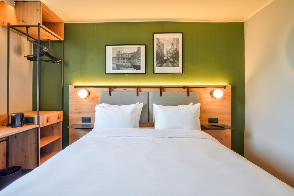 een slaapkamer met een groot bed met een groene muur bij Campanile Paris Ouest - Pont de Suresnes in Suresnes