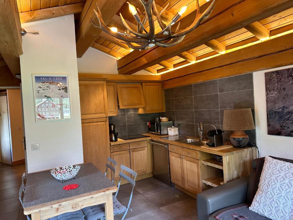 een keuken met houten kasten en een tafel in een kamer bij Chalet Barmaz in Val dʼIsère