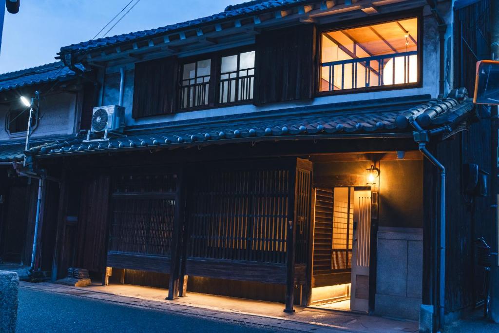 un edificio antiguo con una ventana en el costado en Johns House じょんのやど, en Himeji