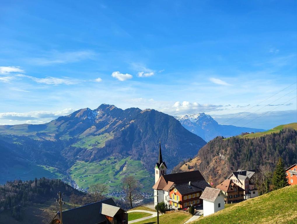 una chiesa su una collina con montagne sullo sfondo di Pilgerhaus Maria-Rickenbach - Anreise nur via Luftseilbahn möglich a Dallenwil