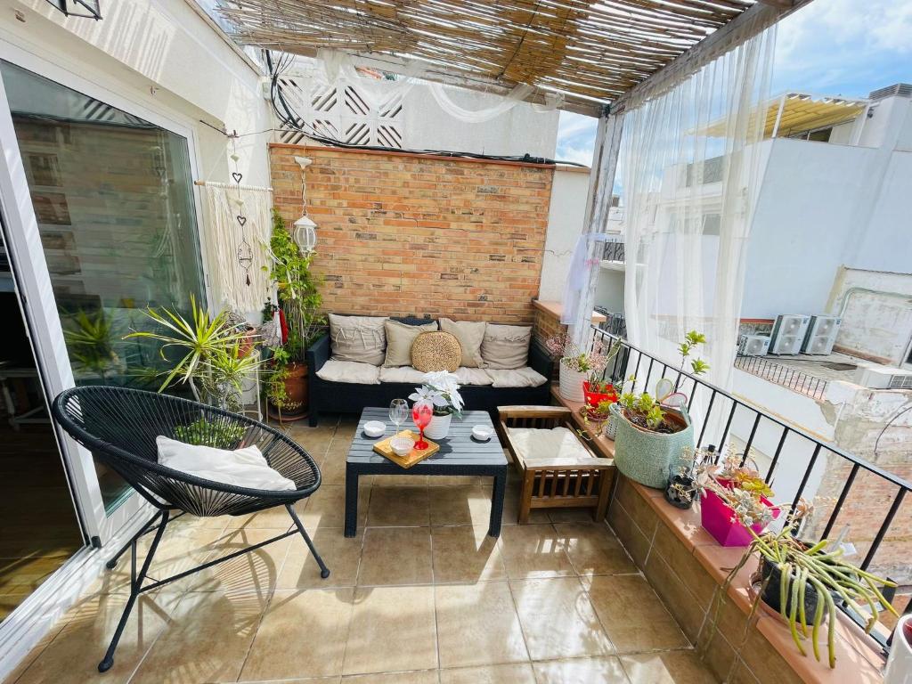 a patio with a couch and a table on a balcony at Sweet Atic in Sitges