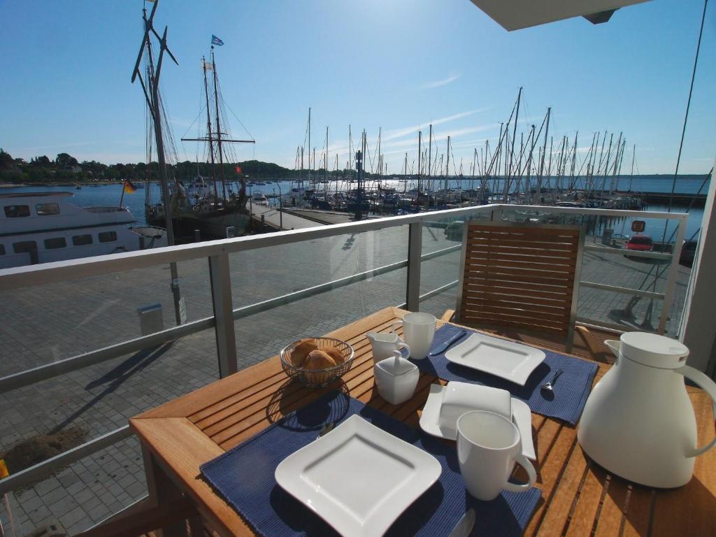 una mesa en un balcón con vistas al puerto deportivo en Apartmenthaus Hafenspitze Ap 10 - "Borbyblick" - Blickrichtung Hafen und offene See - a72335, en Eckernförde