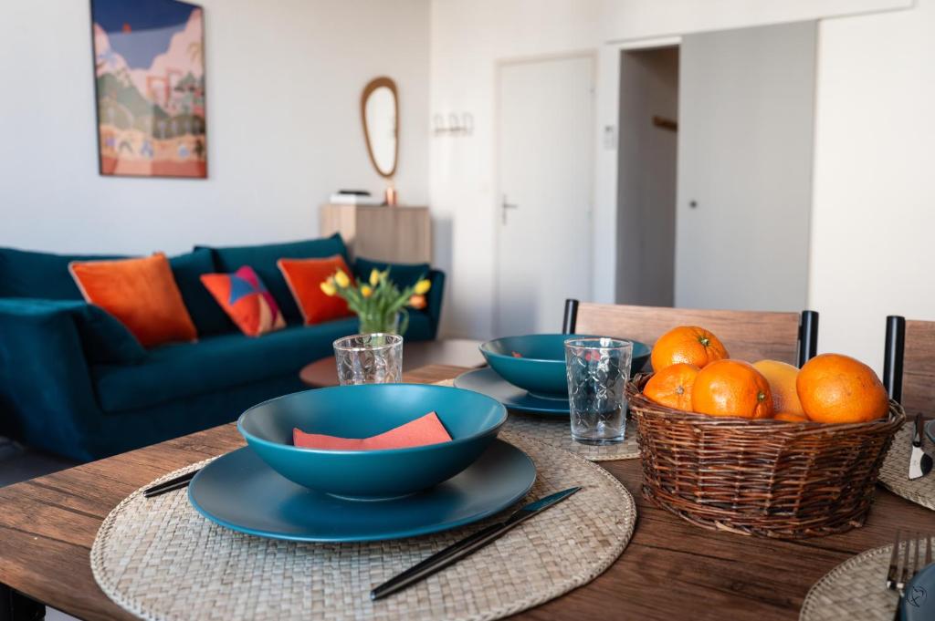 - une table à manger avec des bols bleus et des oranges dans l'établissement Orange Sunset, à Draguignan