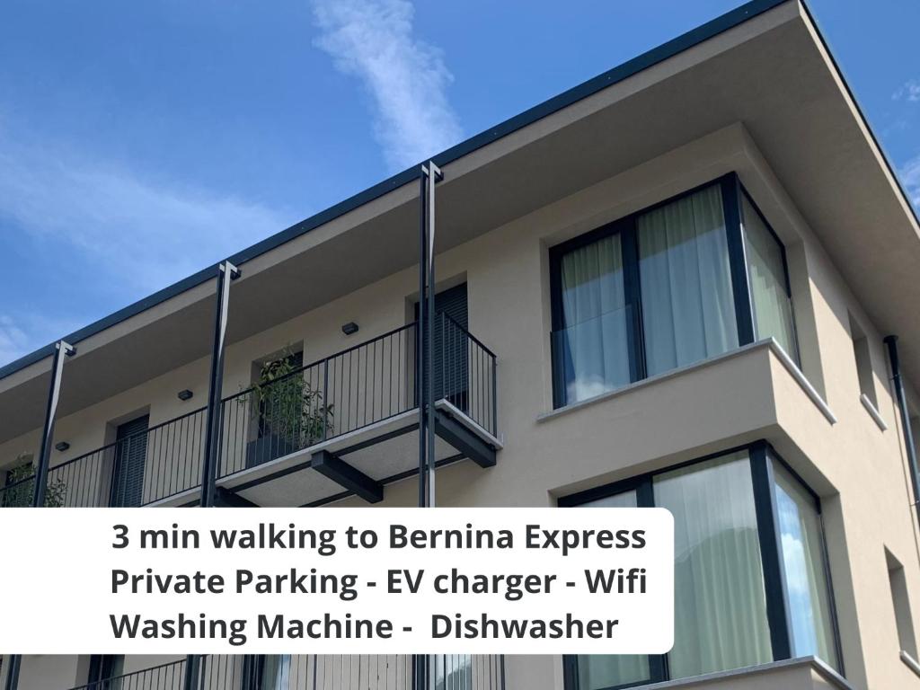 un edificio con un letrero que lee min caminando hacia el aparcamiento privado exprés de Beenna en Bernina Suites - vicino al Bernina Express, en Tirano