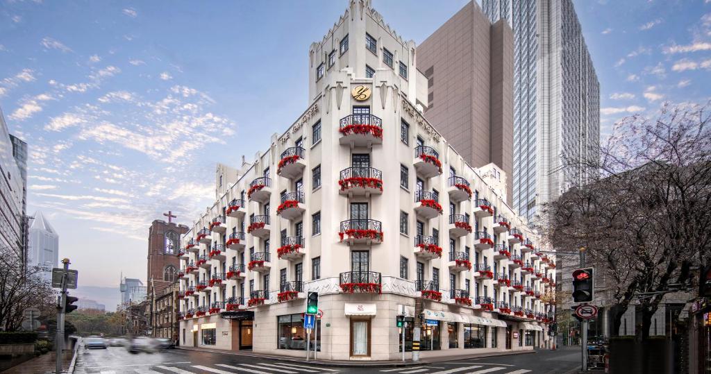 Un grand bâtiment blanc avec une horloge en haut dans l'établissement The Yangtze Boutique Shanghai, à Shanghai