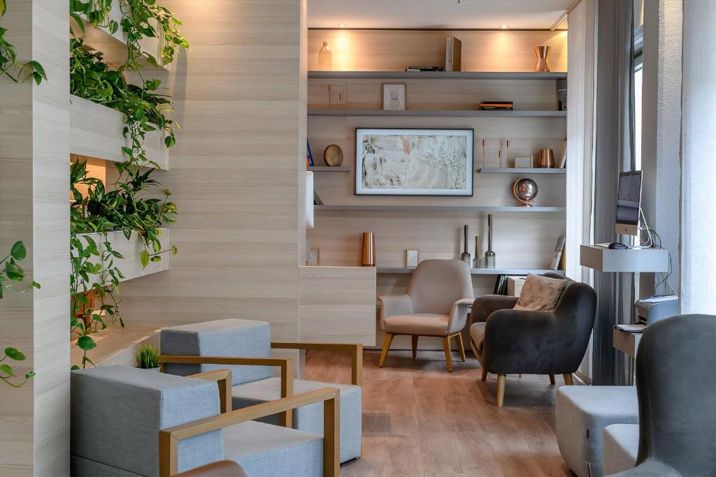 a waiting room with chairs and a table and a desk at Novotel Frankfurt City in Frankfurt/Main