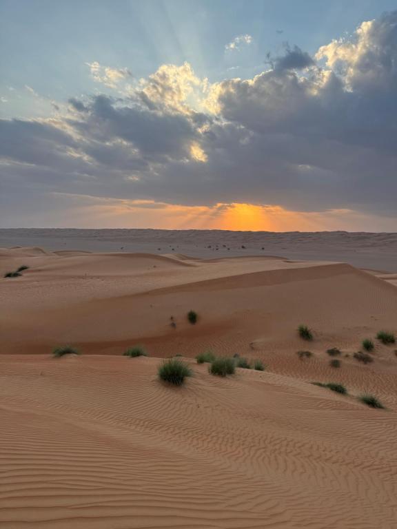 una puesta de sol sobre las dunas de arena en el desierto en Alsarmadi Desert Camp, en Shāhiq