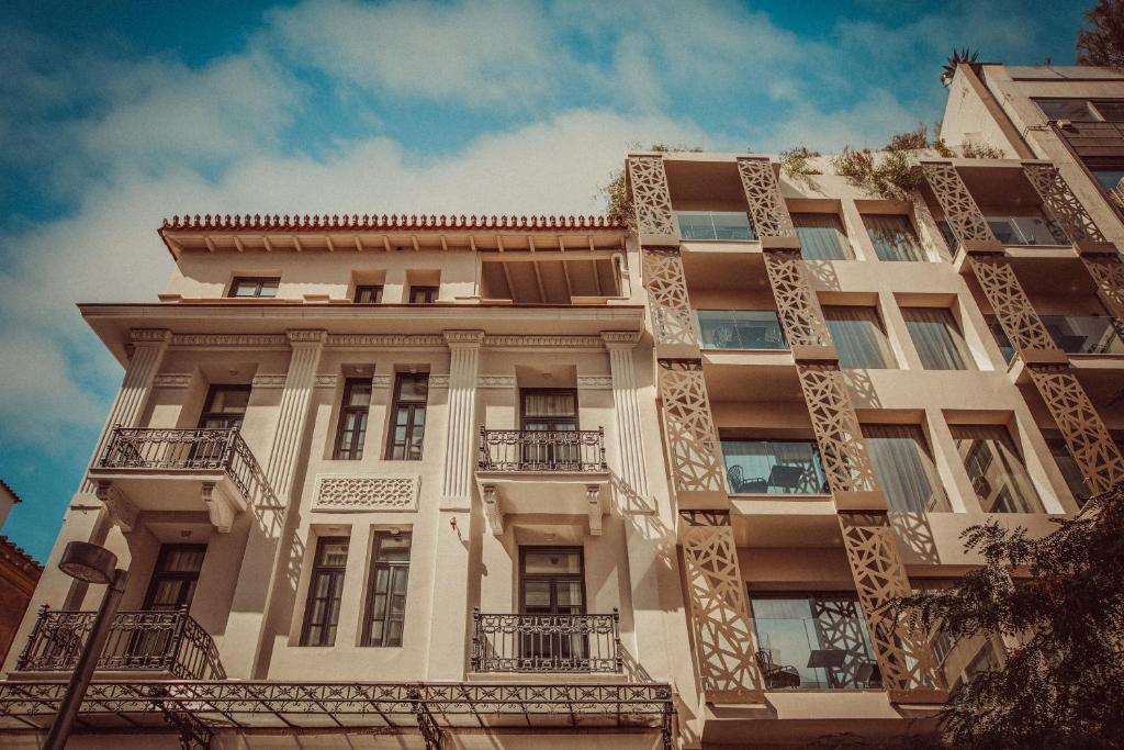 d'un grand bâtiment blanc avec balcon. dans l'établissement The Residence Aiolou Hotel & Spa, à Athènes