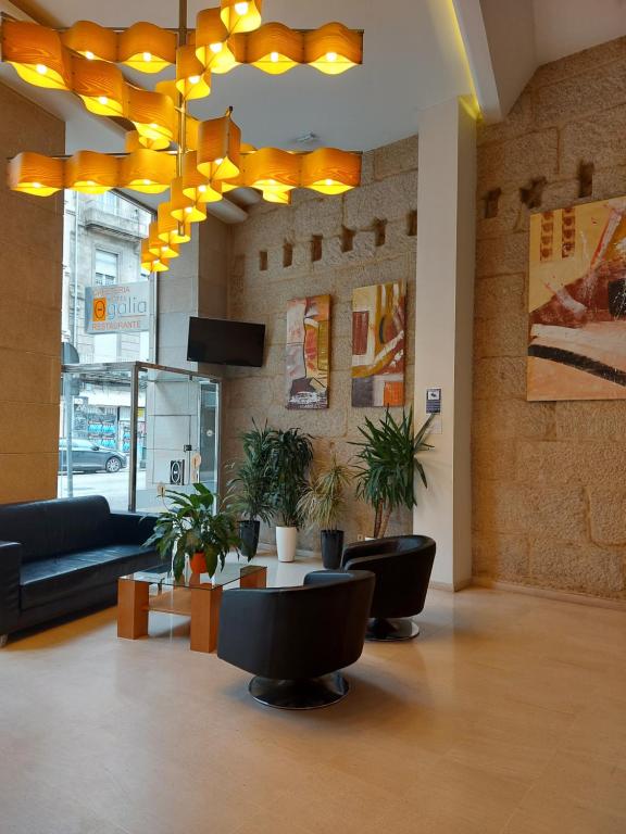 eine Lobby mit einem Sofa, einem Tisch und Stühlen in der Unterkunft U Hotel Ogalia Vigo in Vigo