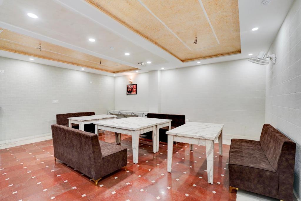 une salle à manger avec des tables et des chaises et un plafond dans l'établissement Hotel Taj Holiday, à Agra