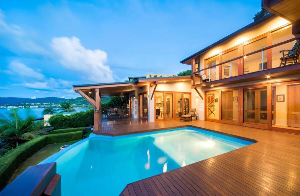 una casa con piscina di fronte a una casa di Amazing Whitsunday Views at High Tide a Cannonvale