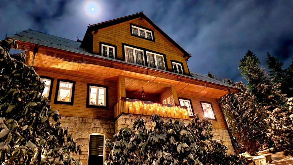 uma casa de madeira com a lua no céu em Willa 1910 em Karpacz