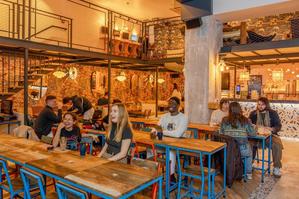 um grupo de pessoas sentadas em mesas em um restaurante em Villa Saint Exupery Beach Hostel em Nice