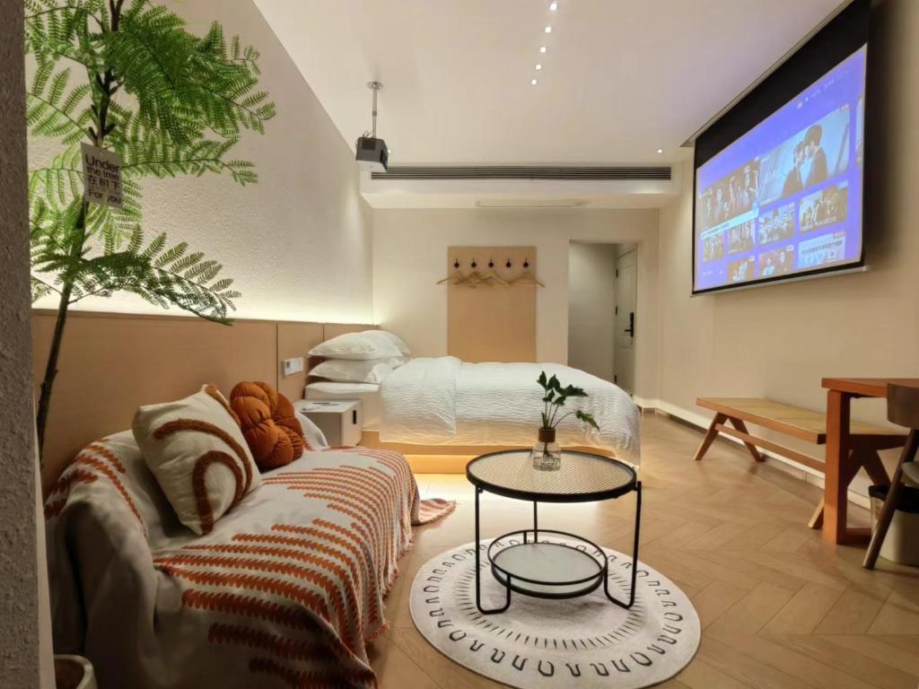 a living room with a couch and a bed at Flower Whisperer Homestay in Zhangjiajie