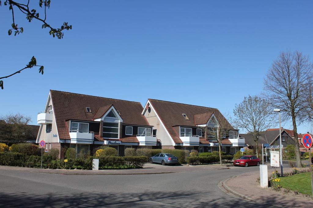 een rij huizen met auto's geparkeerd in een straat bij Apartmenthaus Padua in Büsum