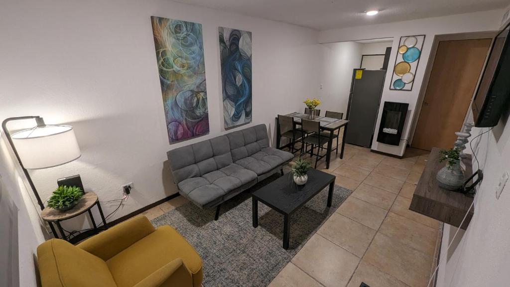 een woonkamer met een bank en een tafel bij Acogedora Casa in Ciudad Juárez