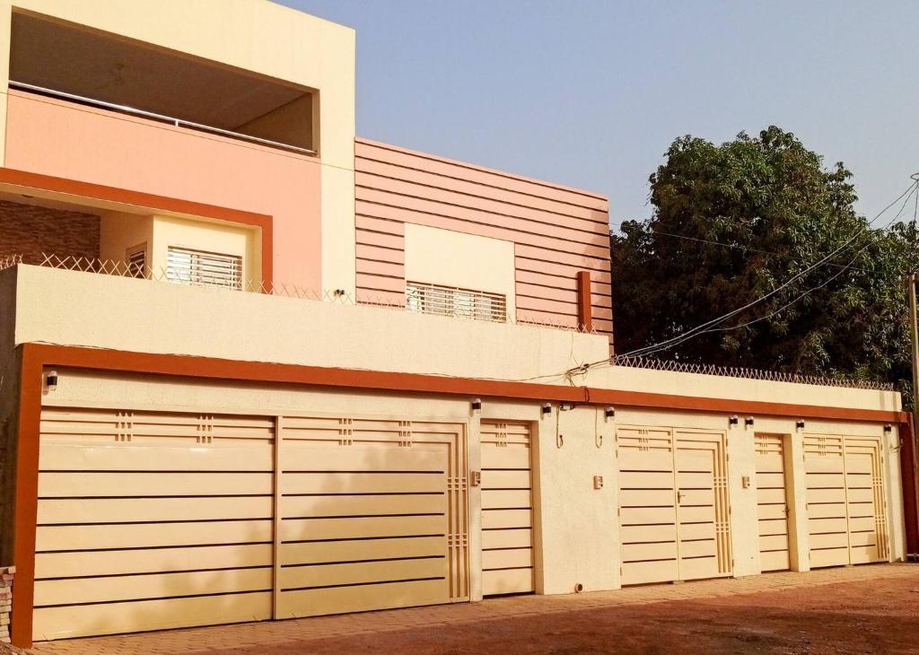 um par de portas de garagem em frente a uma casa em Kadoued Furnished Apartment 2 Bedroom em Ouagadougou