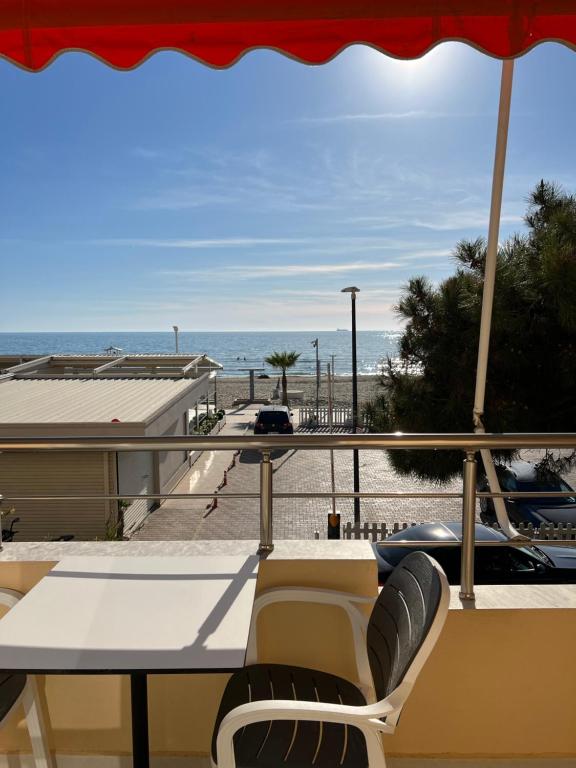 uma varanda com mesa e cadeiras e a praia em SKetch Apartments 2 em Durrës