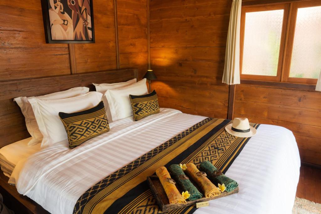 A bed or beds in a room at Kayu Village