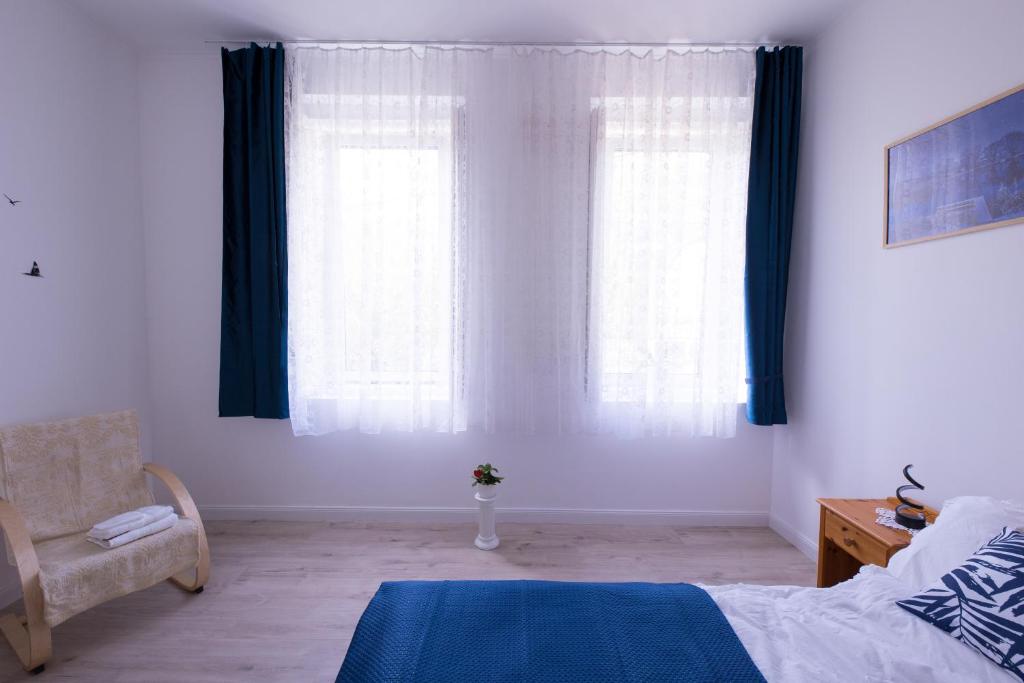 una camera da letto con tende blu, un letto e una sedia di Wagner Villa 902 with free private parking a Budapest