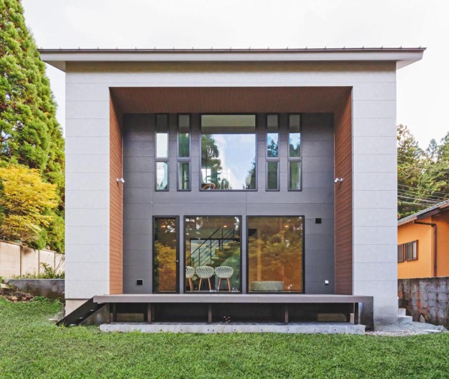 une maison avec un banc devant elle dans l'établissement Hakone Ashinoko Lakeside Resort - 箱根芦ノ湖レイクサイドリゾート, à Hakone