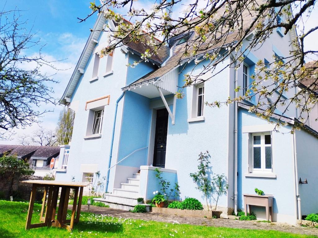 una casa blu e bianca con un tavolo di fronte di Maison de Vacances 1930 a Vannes