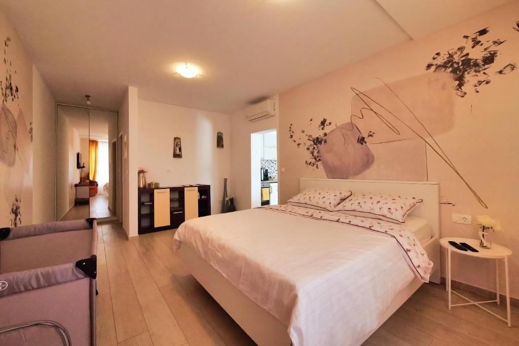 - une chambre avec un grand lit blanc orné d'une peinture murale dans l'établissement Dubrovnik Airport Apartment Pascal, à Močići