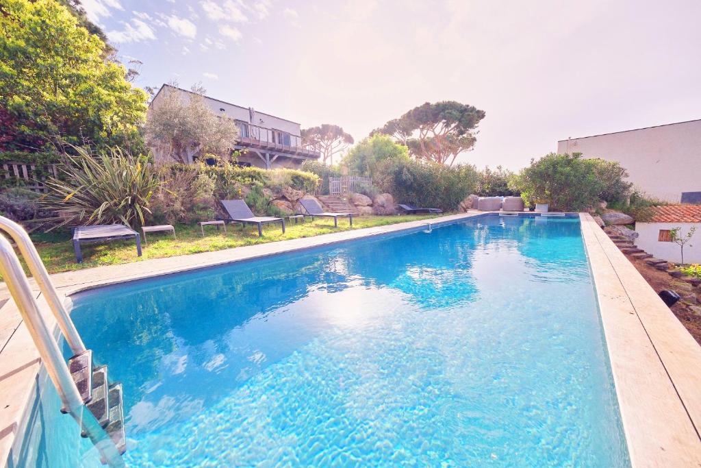 - une grande piscine d'eau bleue dans la cour dans l'établissement Villa avec jardin et piscine, à Calvi