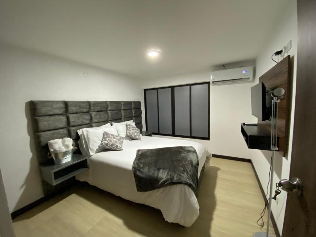 a bedroom with a large bed and a television at Beauté in Pereira